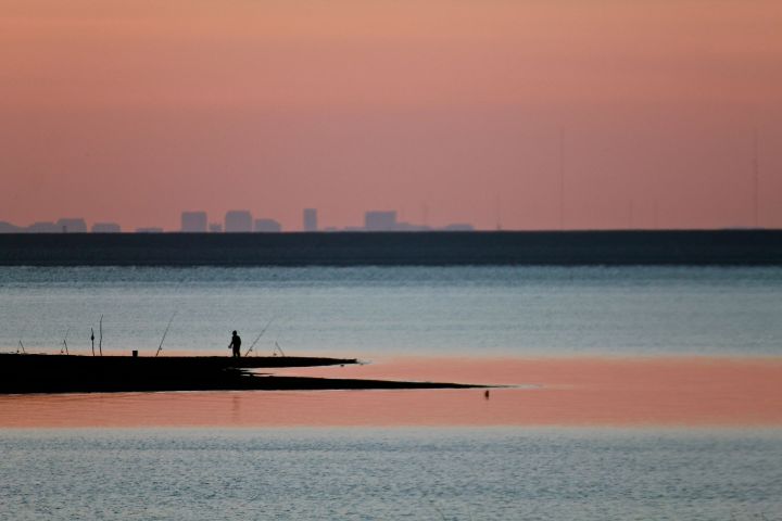 Alone at the shoreline; the distance skyline reminds us how close we are to the city....